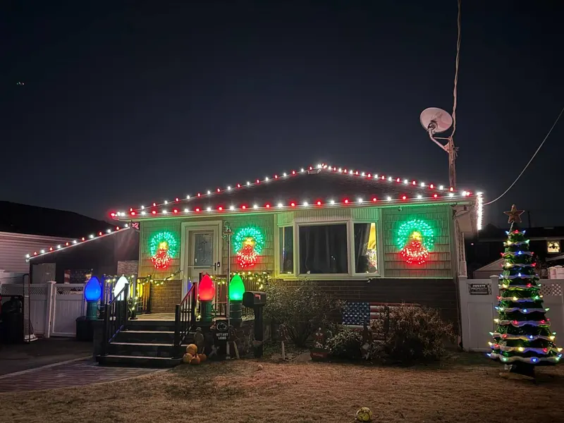 Red white and green Christmas lighting on a ranch home